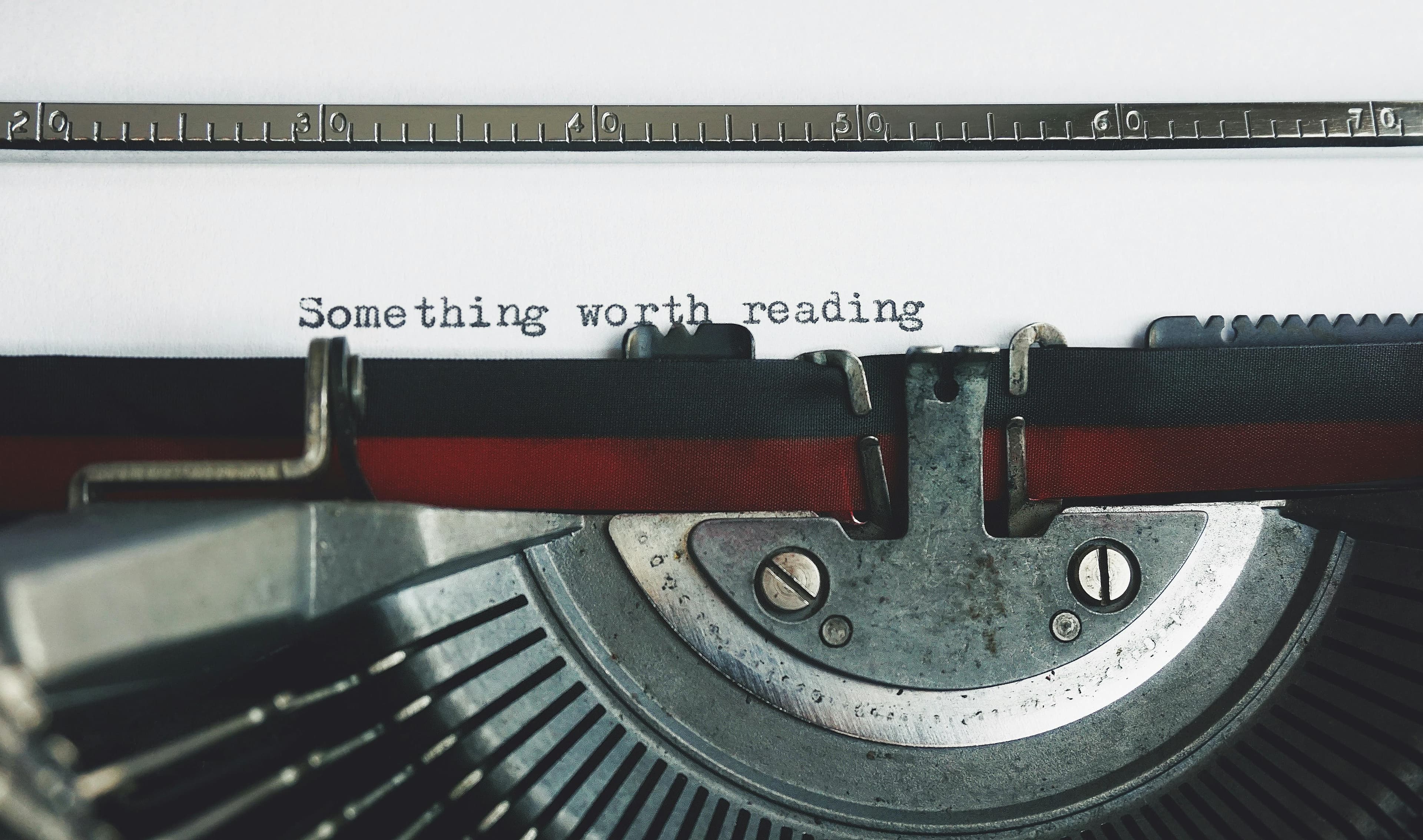 The background cover for our blog posts page. It shows a typewriter, typing out "something worth reading"